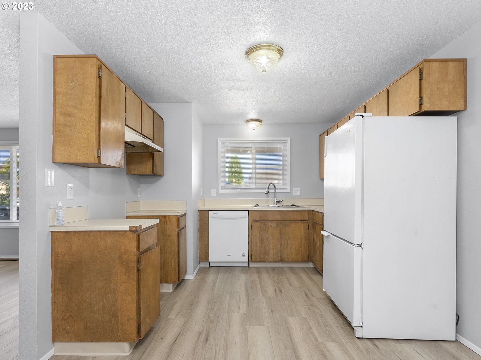 964 Southwest 179th Avenue Beaverton, OR 97003 - Photo 11 of 27 a kitchen with a refrigerator a stove top oven a sink and dishwasher with wooden floor