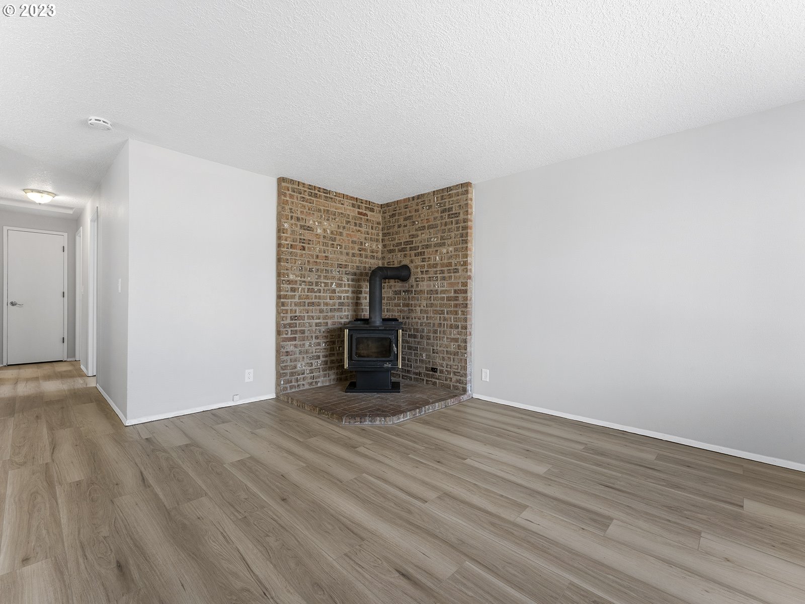 964 Southwest 179th Avenue Beaverton, OR 97003 - Photo 2 of 27 a view of an empty room with wooden floor and a fireplace