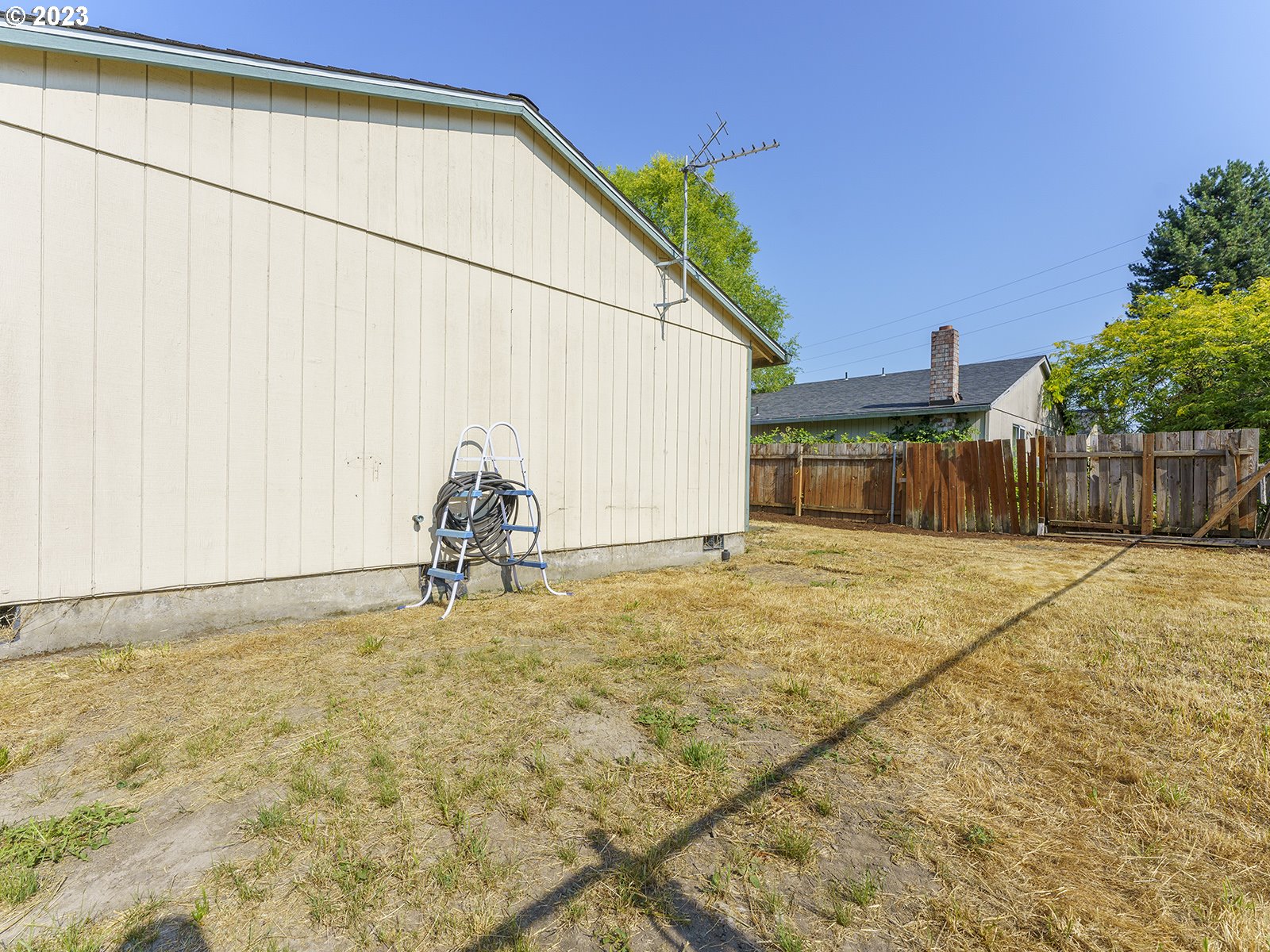 964 Southwest 179th Avenue Beaverton, OR 97003 - Photo 26 of 27 a backyard of a house with table and chairs and a large tree