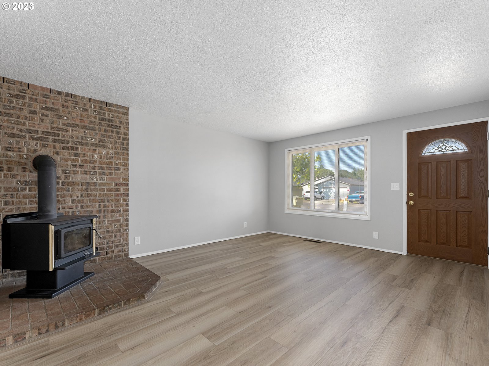 964 Southwest 179th Avenue Beaverton, OR 97003 - Photo 4 of 27 an empty room with windows fireplace and wooden floor