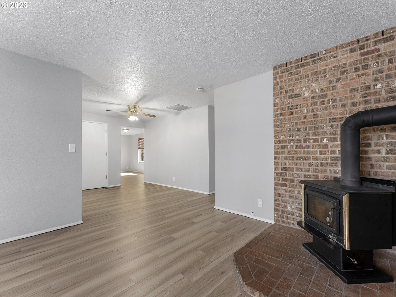 964 Southwest 179th Avenue Beaverton, OR 97003 - Photo 6 of 27 an empty room with wooden floor fireplace and a window
