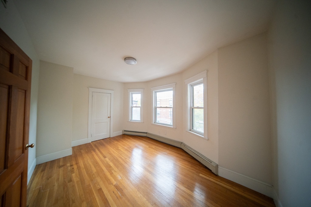 208 Rawson Road, Unit 3 Brookline, MA 02445 - Photo 13 of 33 a view of empty room with wooden floor and fan