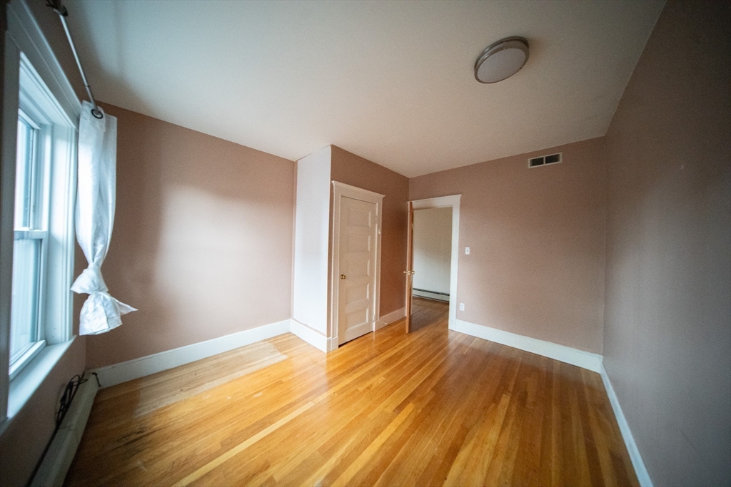 208 Rawson Road, Unit 3 Brookline, MA 02445 - Photo 15 of 33 a view of an empty room with wooden floor and a window