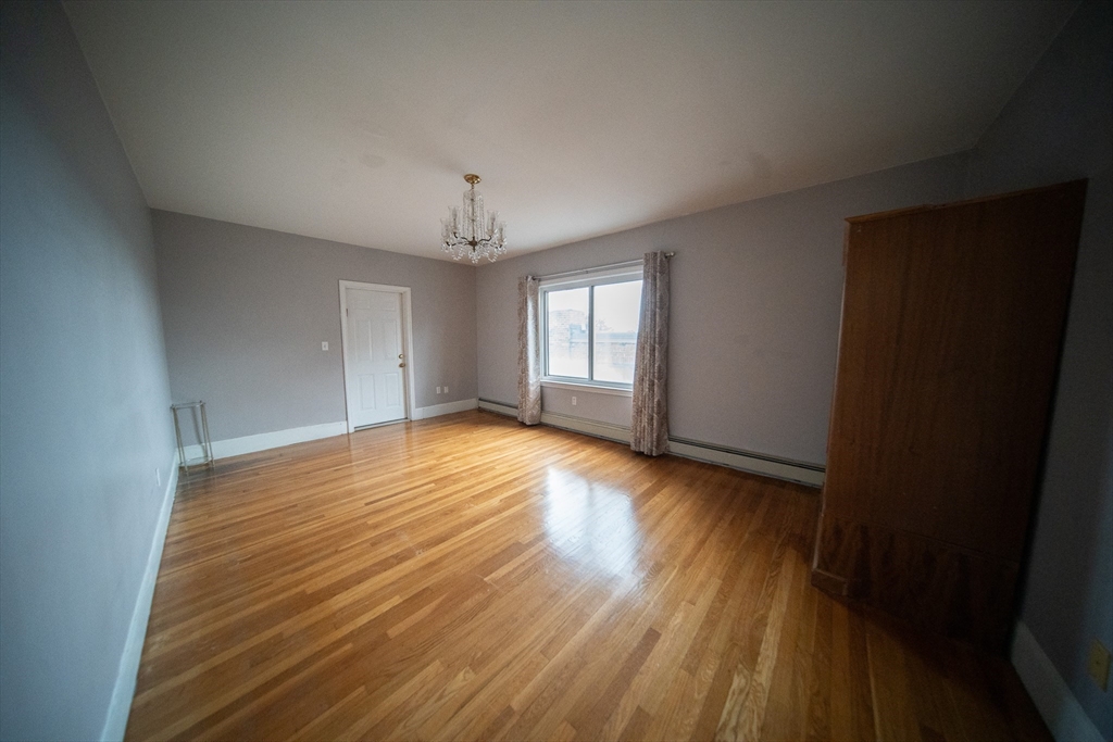 208 Rawson Road, Unit 2 Brookline, MA 02445 - Photo 19 of 33 a view of empty room with wooden floor and fan