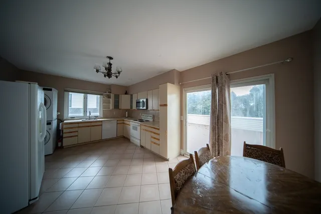 a kitchen with a refrigerator and white cabinets