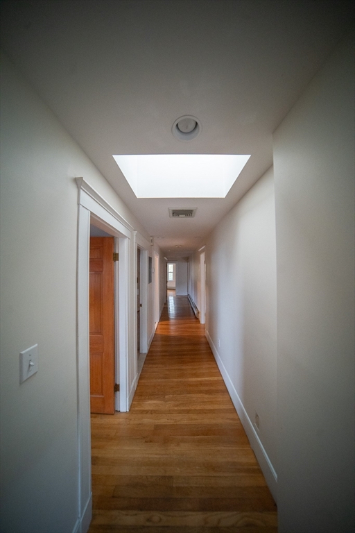 208 Rawson Road, Unit 2 Brookline, MA 02445 - Photo 5 of 33 a view of a hallway with wooden floor and staircase