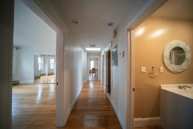 a view of a hallway with wooden floor