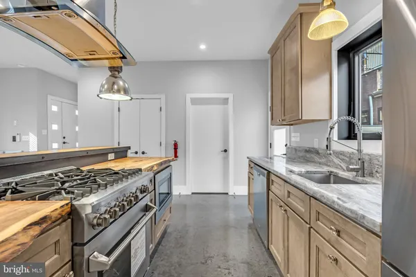 a kitchen with stainless steel appliances granite countertop a stove and a sink