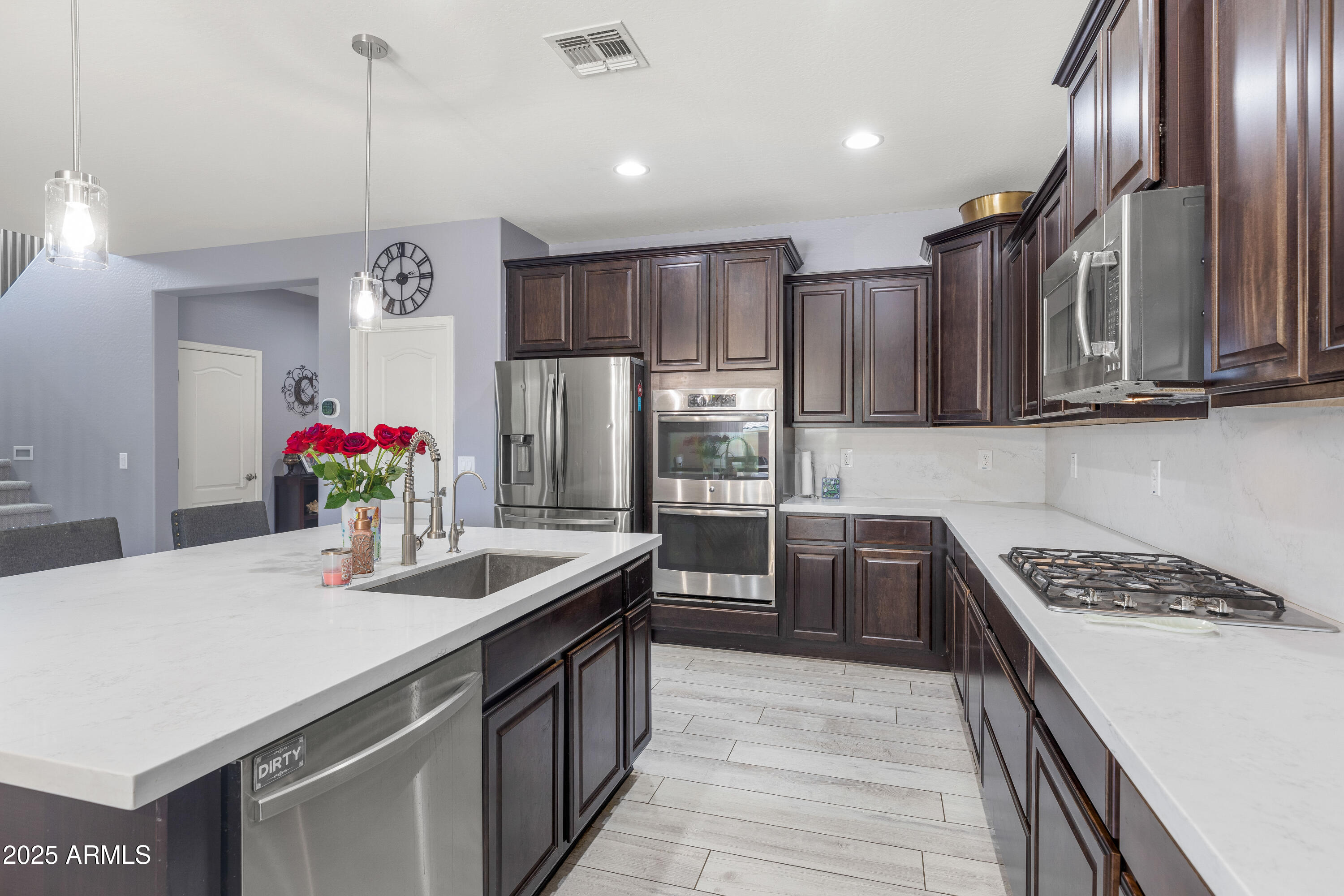 18649 West Williams Street Goodyear, AZ 85338 - Photo 11 of 42 a kitchen with kitchen island granite countertop a sink stainless steel appliances and cabinets