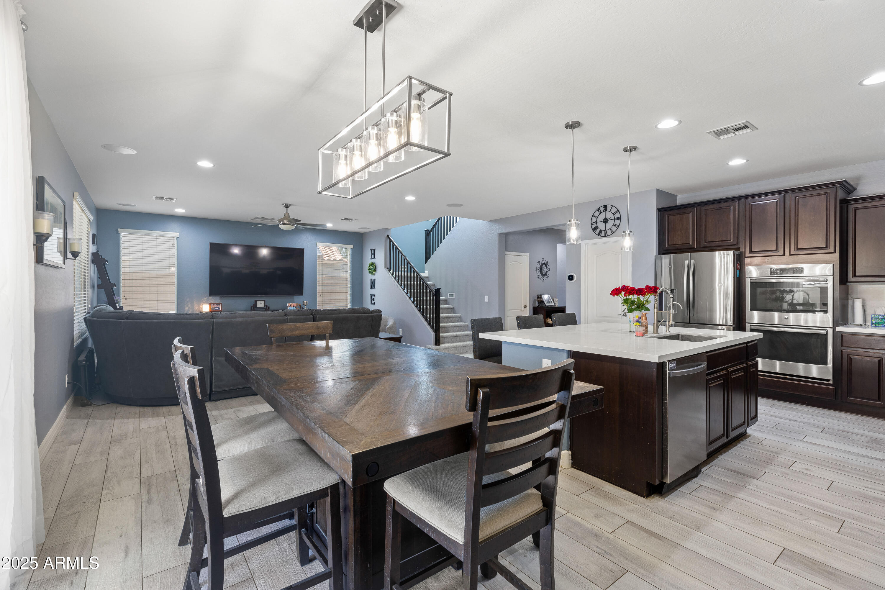 18649 West Williams Street Goodyear, AZ 85338 - Photo 12 of 42 a kitchen with stainless steel appliances granite countertop a kitchen island a stove a table and chairs