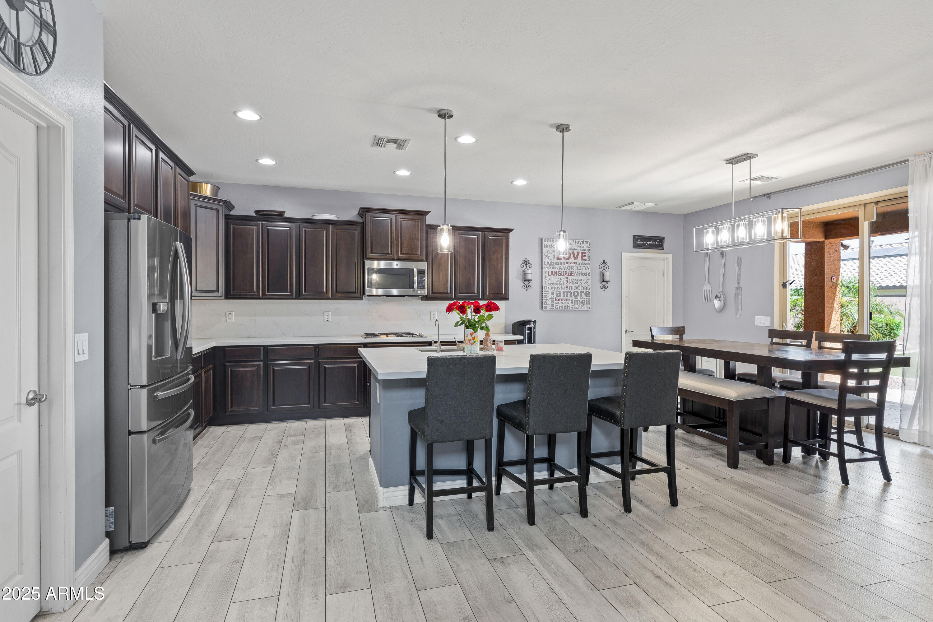 18649 West Williams Street Goodyear, AZ 85338 - Photo 5 of 42 a kitchen with stainless steel appliances kitchen island granite countertop a dining table chairs and sink
