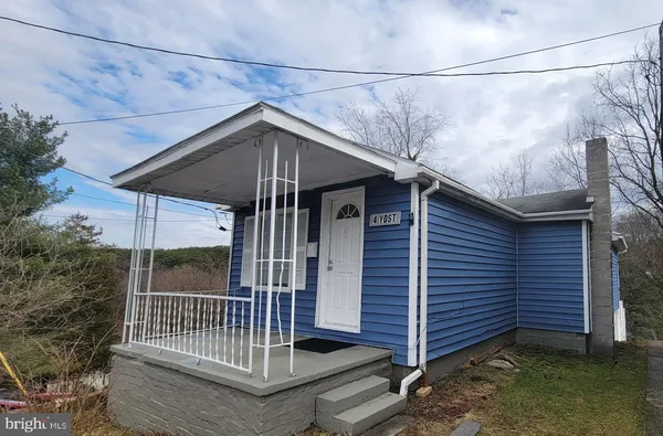 a view of a small house with a small deck and flat screen tv