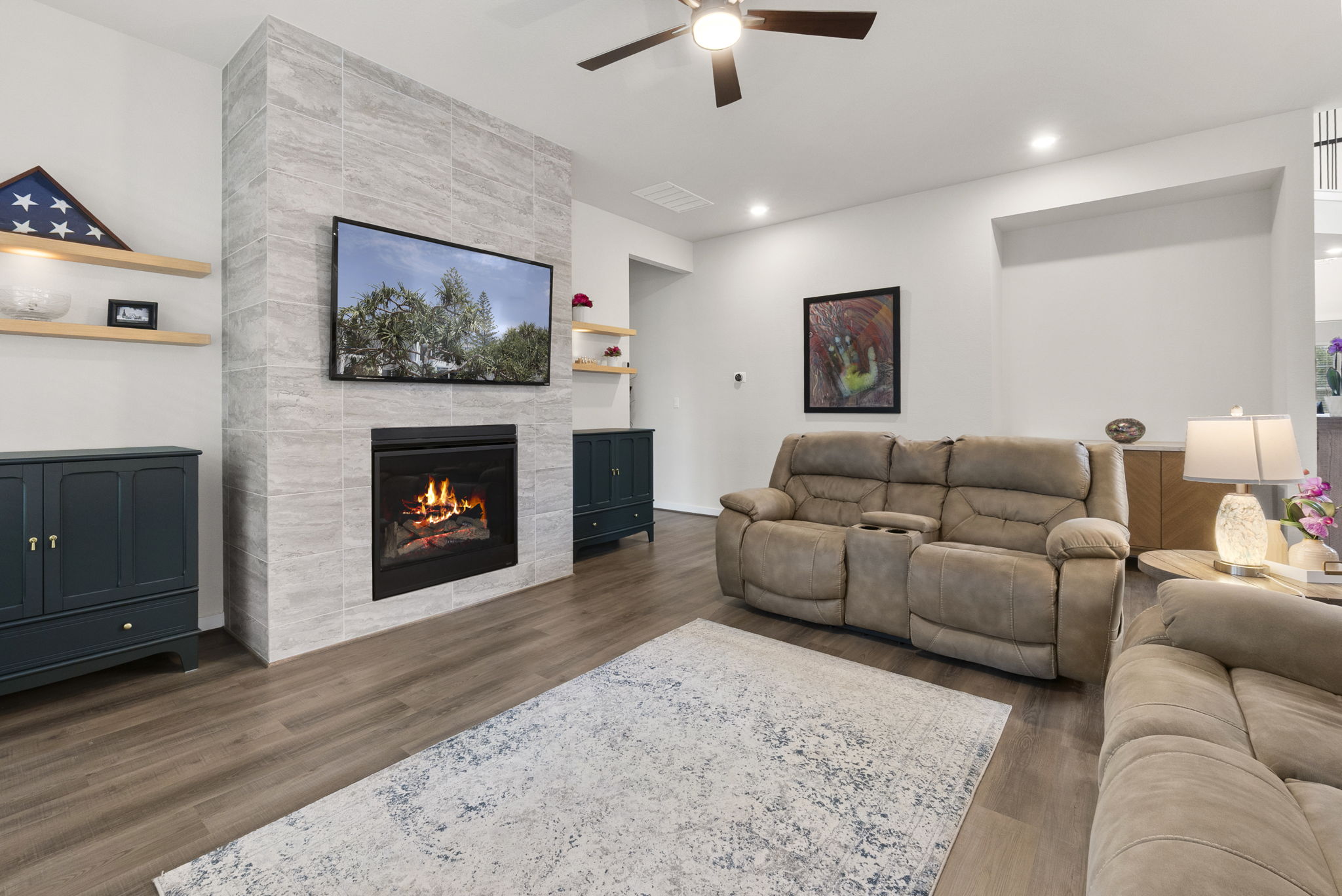 460 Constitution Way Kyle, TX 78640 - Photo 9 of 40 Living area featuring a floor-to-ceiling tiled fireplace, wood-finish flooring, recessed lighting, a ceiling fan, and floating wall shelves