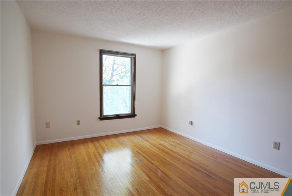 4704 Hana Road Edison, NJ 08817 - Photo 13 of 15 an empty room with wooden floor and windows
