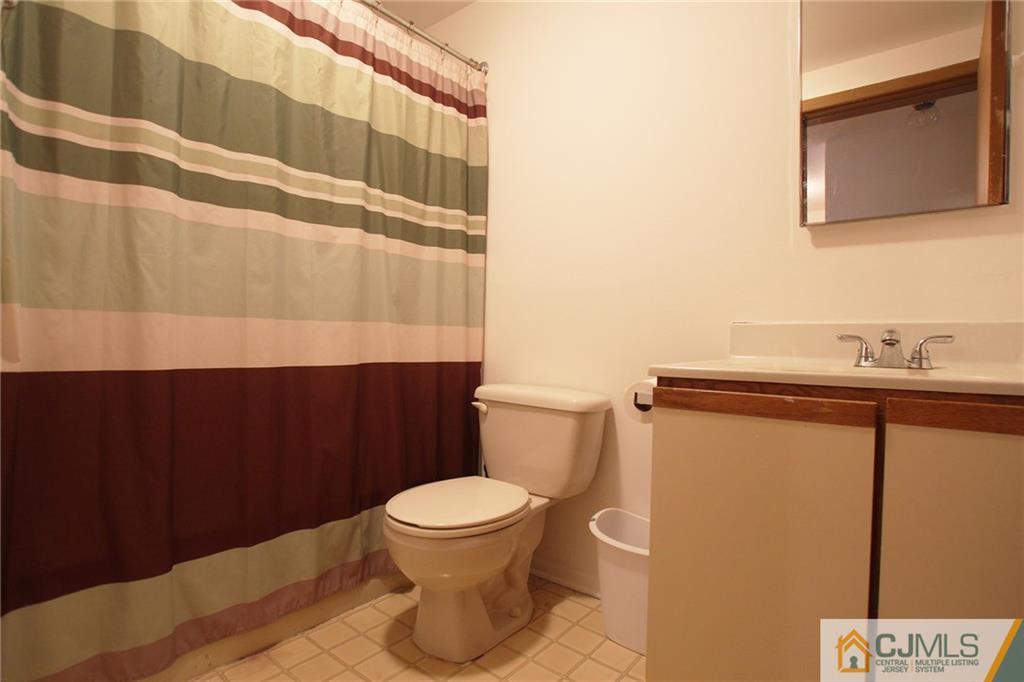 4704 Hana Road Edison, NJ 08817 - Photo 14 of 15 a white toilet sitting next to a bathroom sink