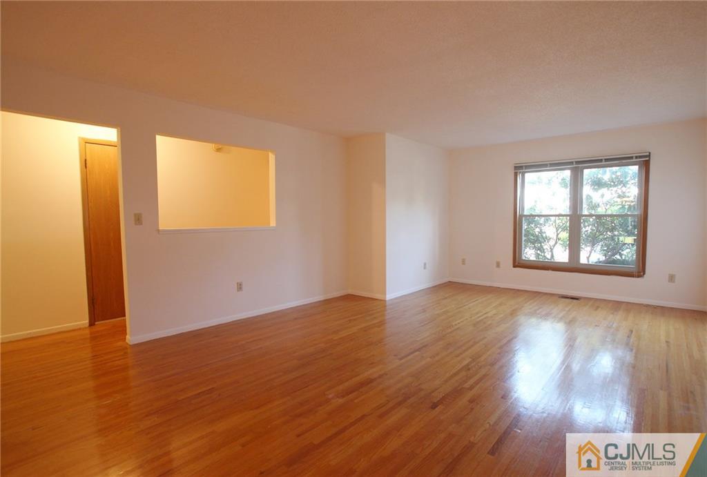 4704 Hana Road Edison, NJ 08817 - Photo 4 of 15 an empty room with wooden floor and windows