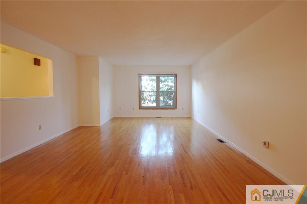 4704 Hana Road Edison, NJ 08817 - Photo 5 of 15 an empty room with wooden floor and windows