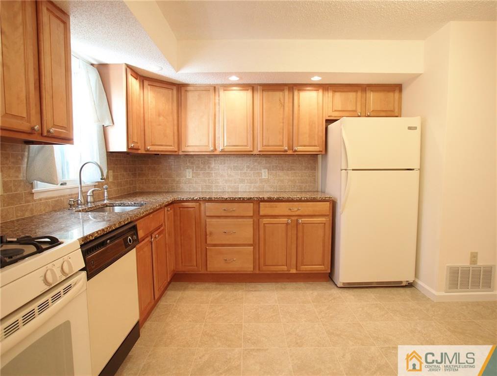 4704 Hana Road Edison, NJ 08817 - Photo 8 of 15 a kitchen with a refrigerator sink and cabinets
