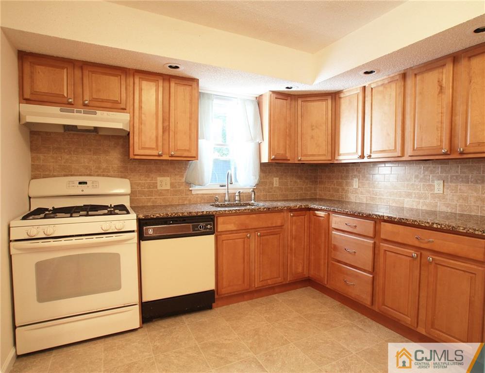 4704 Hana Road Edison, NJ 08817 - Photo 9 of 15 a kitchen with granite countertop cabinets stainless steel appliances a sink and a window