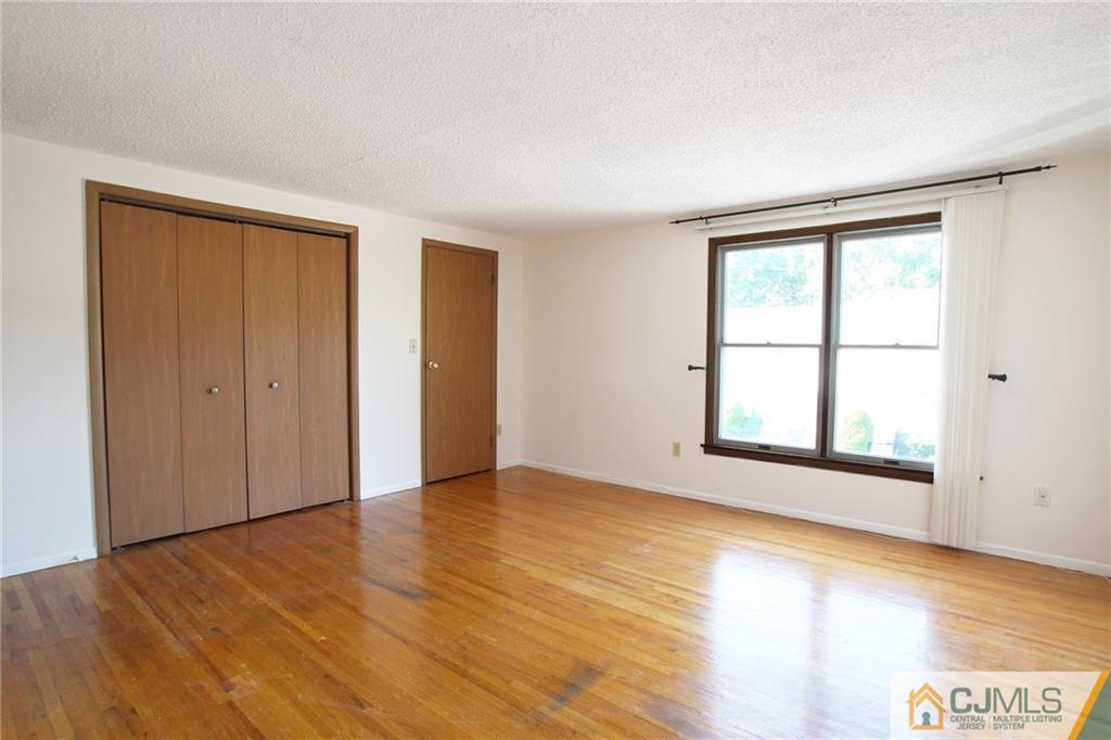 4704 Hana Road Edison, NJ 08817 - Photo 10 of 15 an empty room with wooden floor and windows