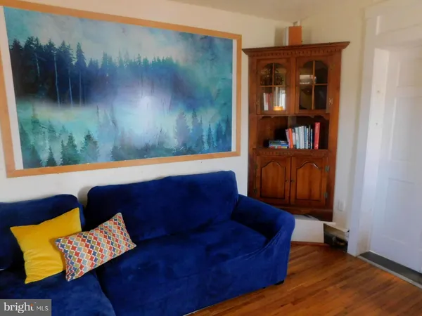 a living room with furniture and a painting on the wall
