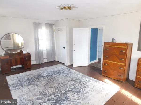 a spacious bedroom with a bed and a dresser in it
