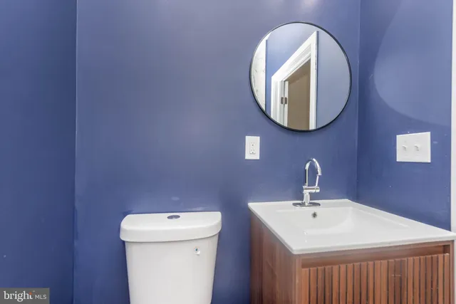 a bathroom with a toilet sink and mirror