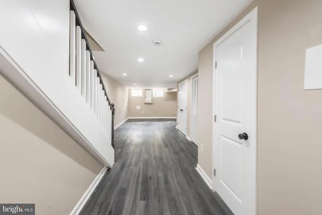 a view of a hallway with wooden floor and staircase
