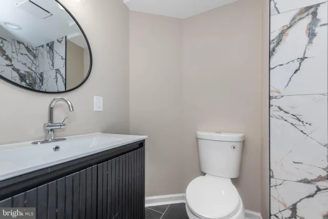 a bathroom with a toilet a sink and mirror