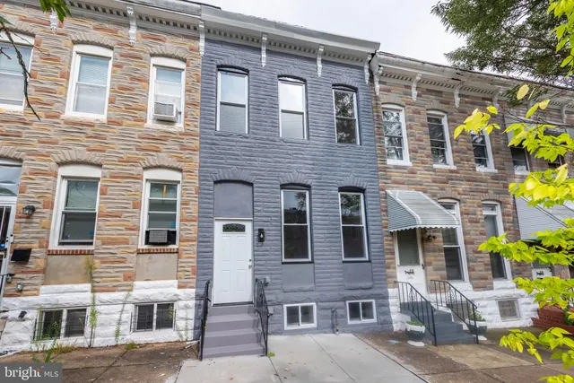a front view of a building with a garden
