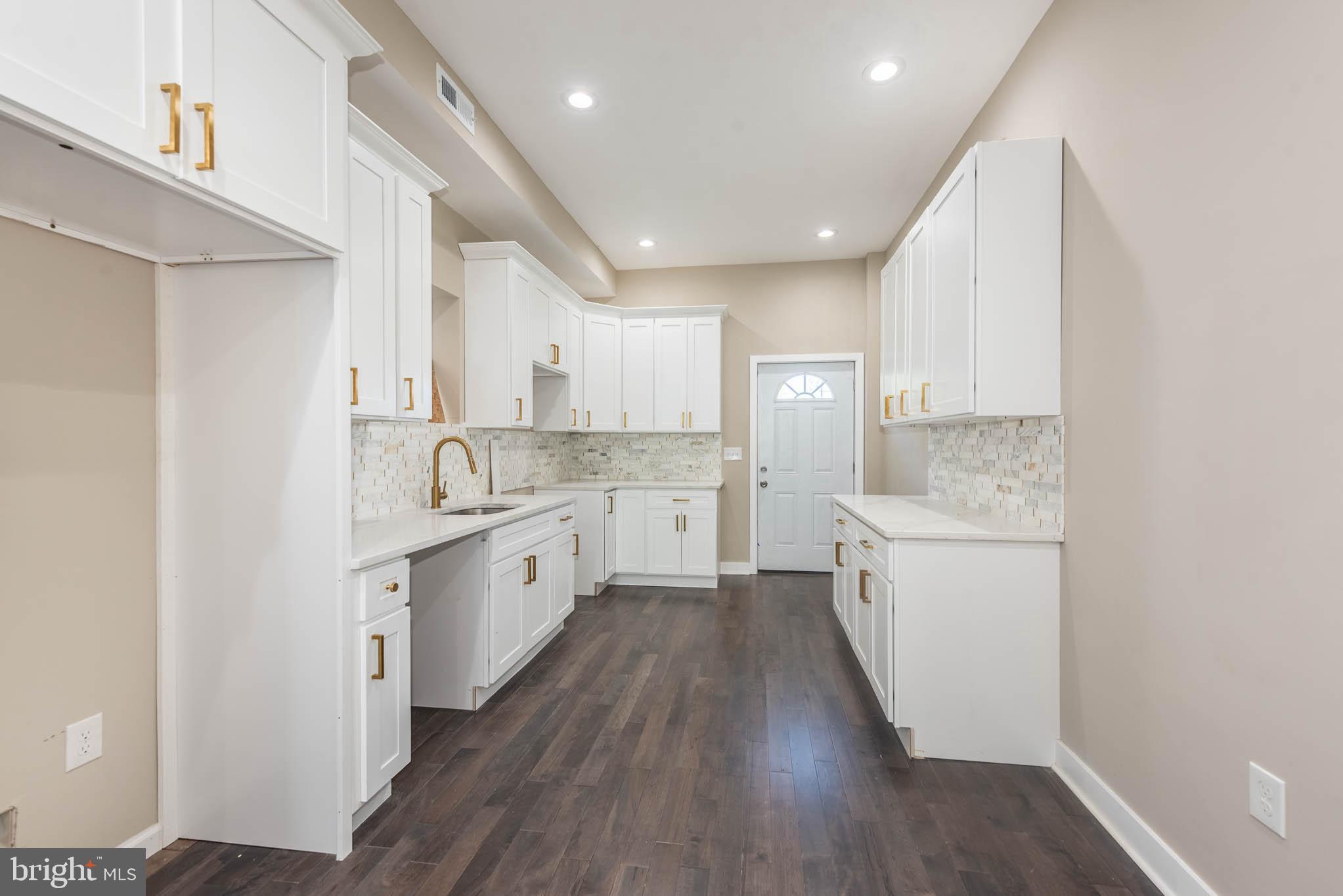 1713 North Bond Street Baltimore, MD 21213 - Photo 6 of 33 a large kitchen with a lot of counter space and wooden floor