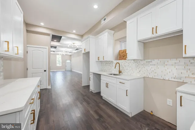 a kitchen with granite countertop a sink cabinets stainless steel appliances and a counter space