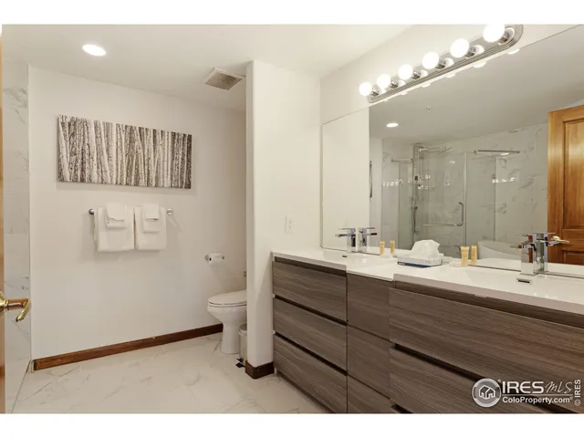 a bathroom with a double vanity sink mirror and toilet