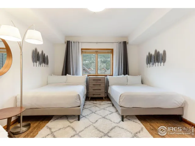 a bedroom with a bed a mirror and a large window