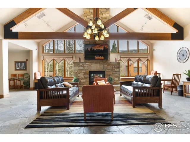 a living room with fireplace furniture and a large window