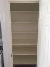 a view of walk in closet with empty racks