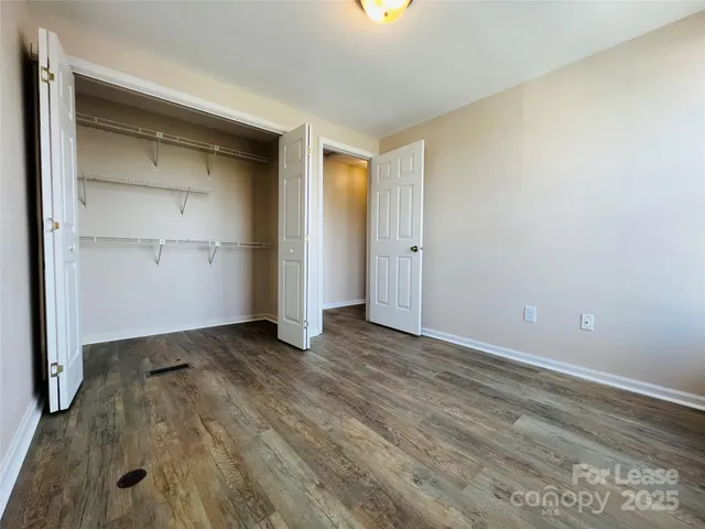 an empty room with closet and wooden floor