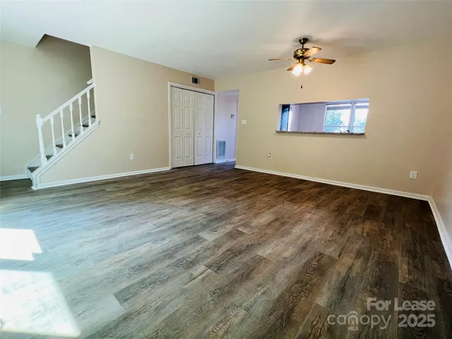 a view of an empty room with a chandelier fan