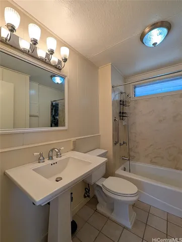 a bathroom with a sink a toilet a mirror and shower