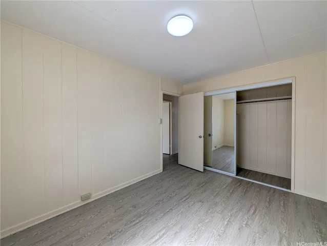 an empty room with wooden floor and window