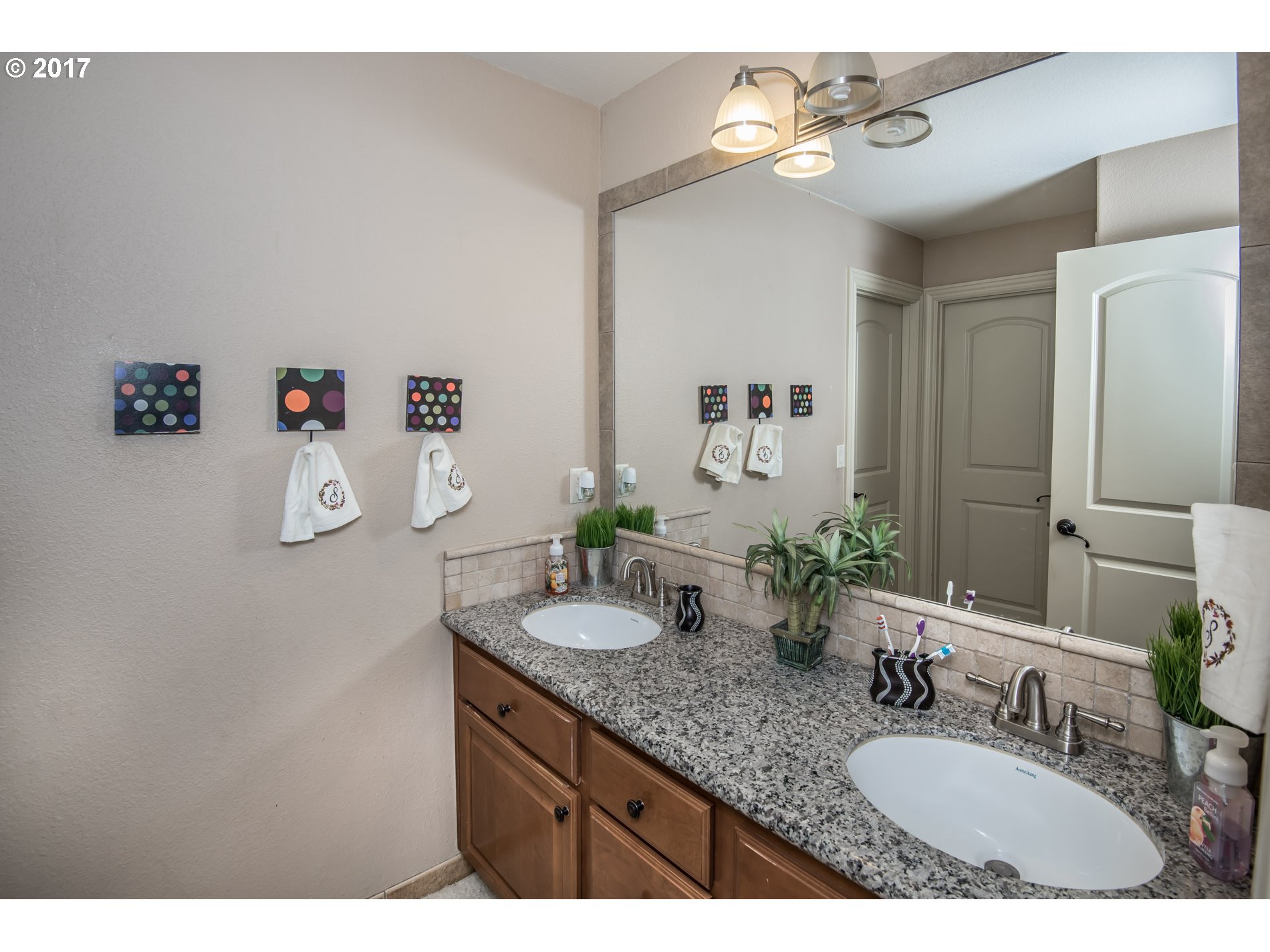 17980 Southeast Vogel Road Damascus, OR 97089 - Photo 23 of 32 a bathroom with a granite countertop sink a large mirror and vanity