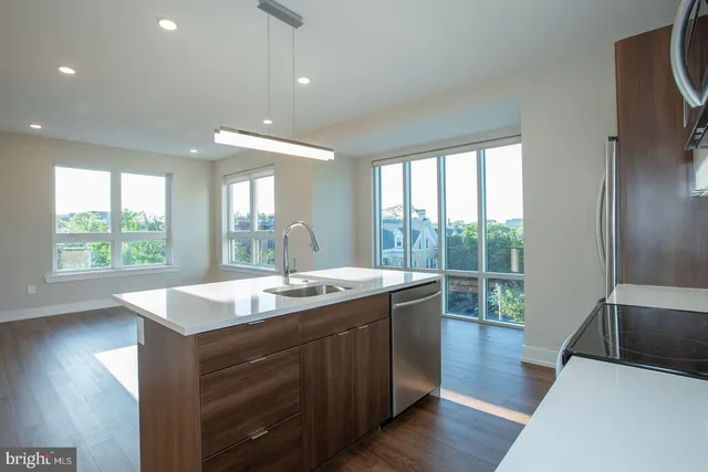 a kitchen with center island wooden floor and a large window