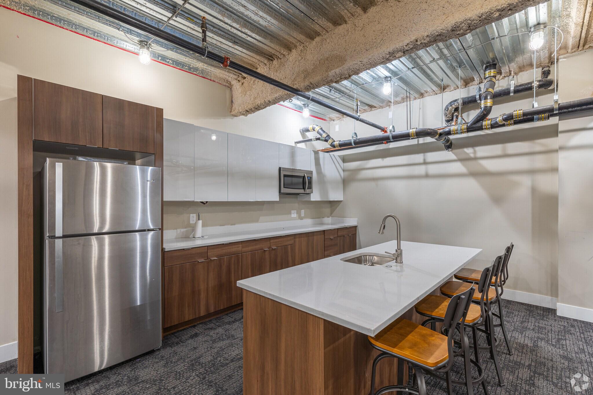 4534 Spruce Street, Unit 1BD3 Philadelphia, PA 19139 - Photo 9 of 9 a kitchen with a table chairs and refrigerator
