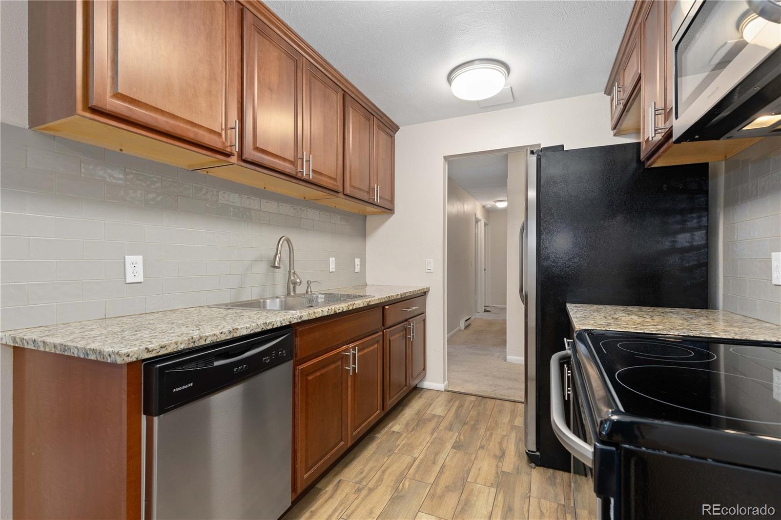 4068 South Atchison Way, Unit 202 Aurora, CO 80014 - Photo 12 of 33 a kitchen with stainless steel appliances granite countertop a sink stove and refrigerator