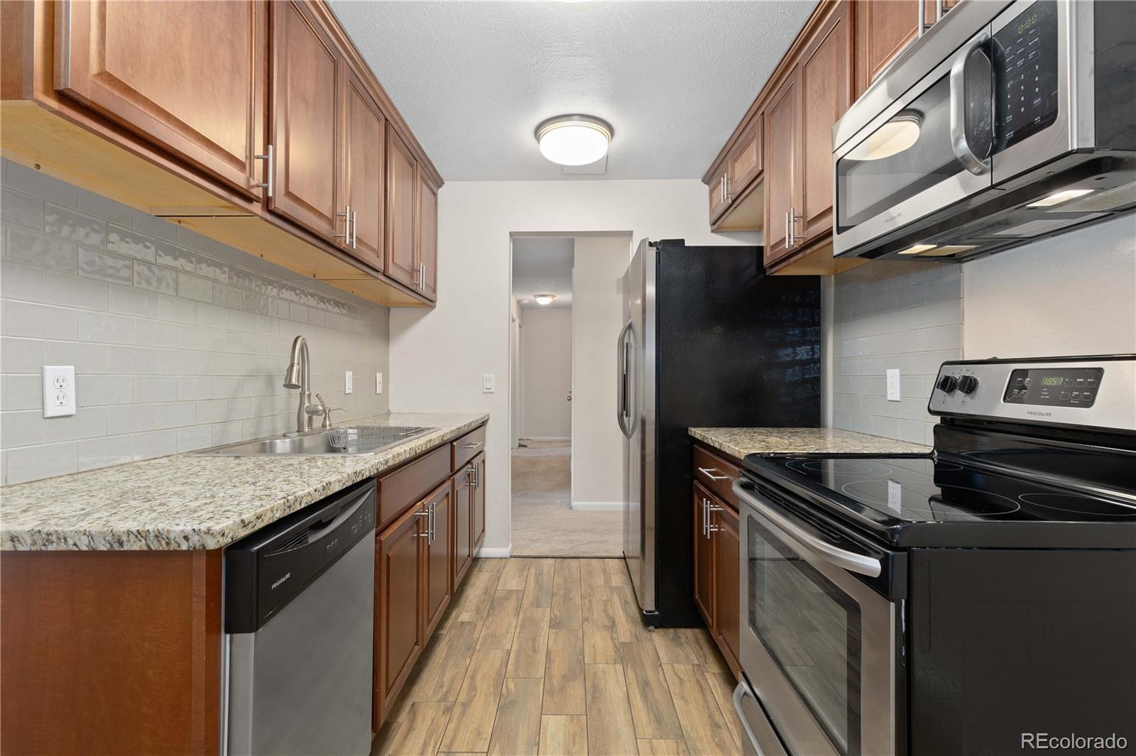 4068 South Atchison Way, Unit 202 Aurora, CO 80014 - Photo 13 of 33 a kitchen with stainless steel appliances granite countertop a sink a stove and cabinets