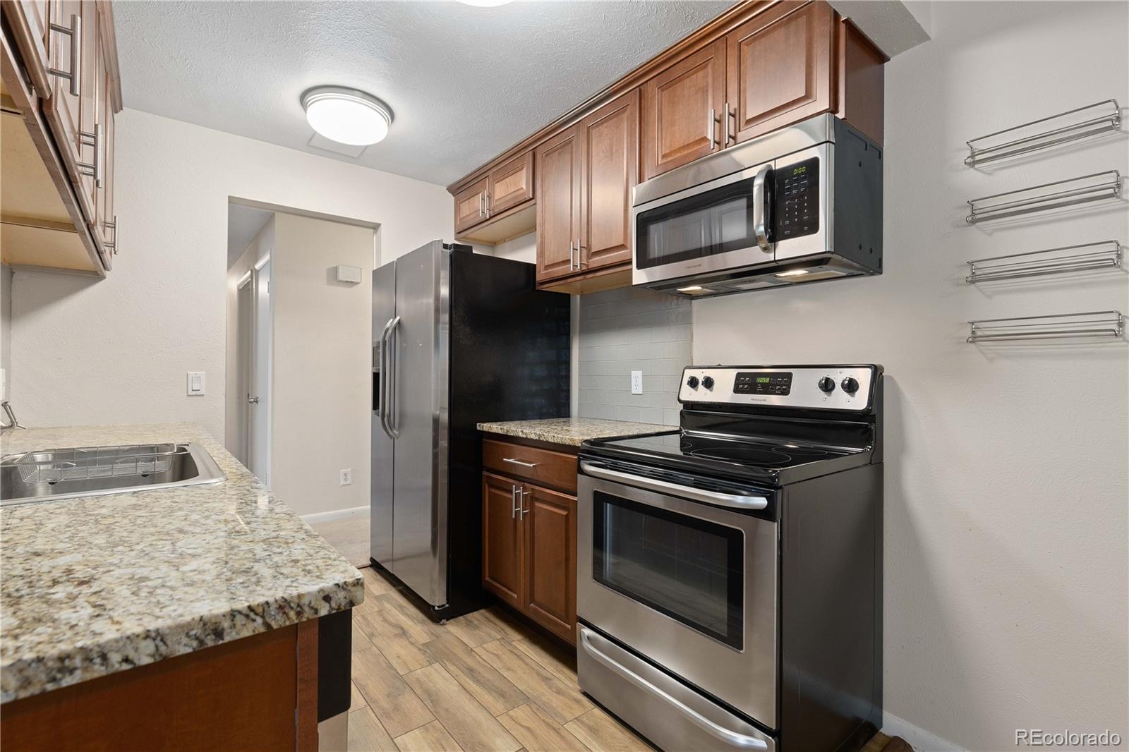 4068 South Atchison Way, Unit 202 Aurora, CO 80014 - Photo 14 of 33 a kitchen with stainless steel appliances granite countertop a stove microwave and refrigerator