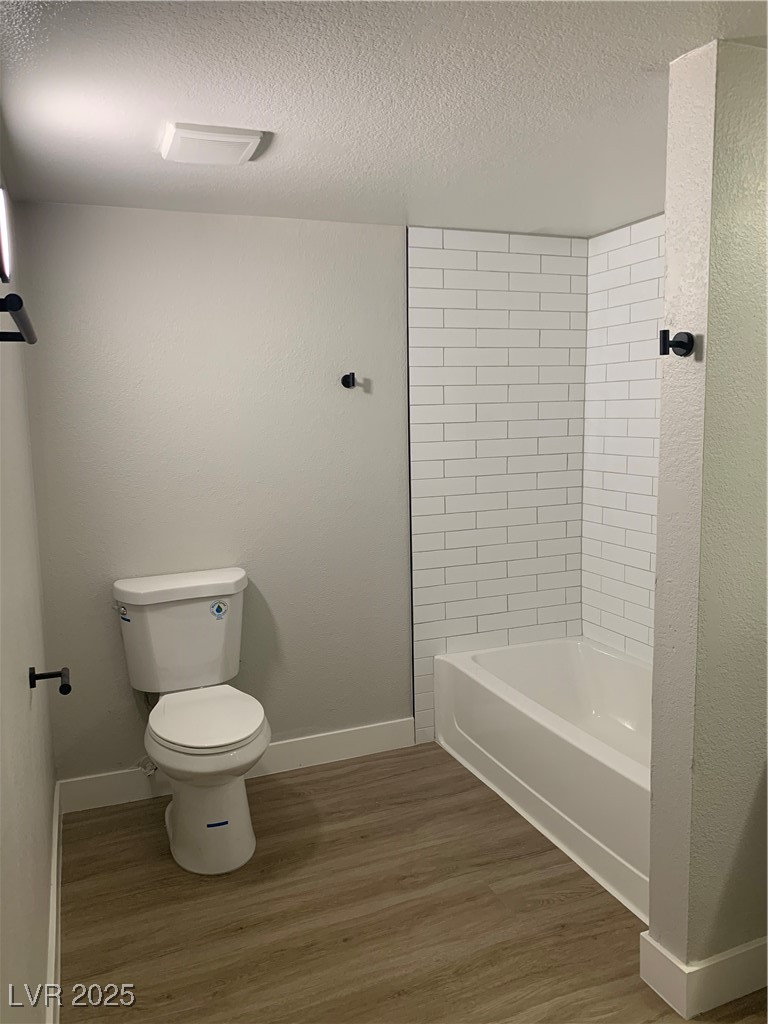 8101 West Flamingo Road, Unit 1102 Las Vegas, NV 89147 - Photo 45 of 54 Bathroom featuring wood finished floors, a textured ceiling, and tub / shower combination
