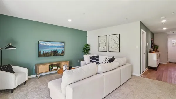 a living room with furniture and a wooden floor