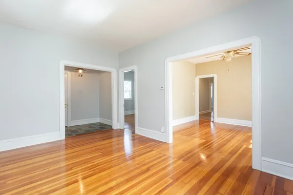 a view of empty room with wooden floor