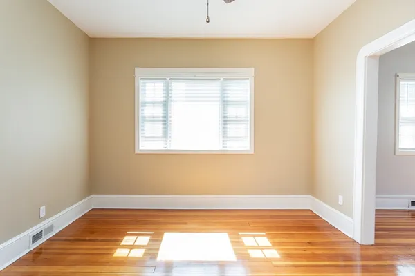 a view of a room with wooden floor and a window
